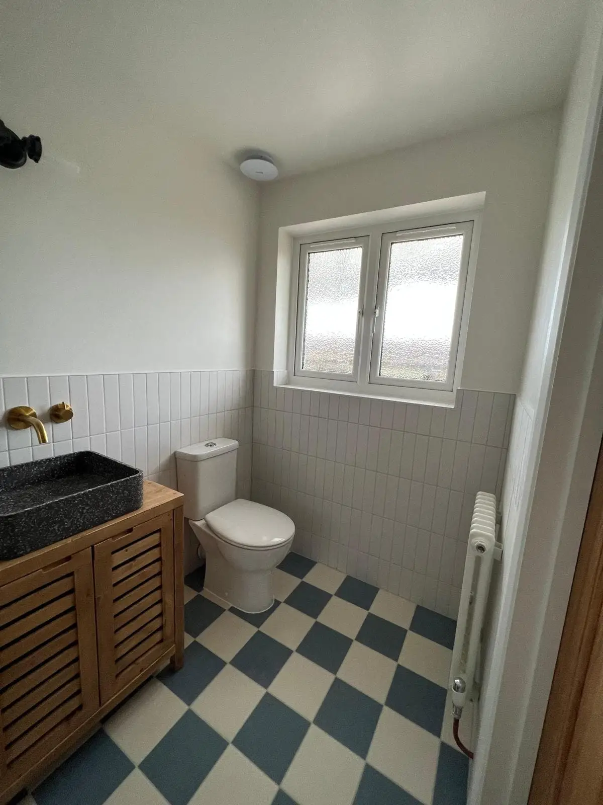 Shower room with a checkerboard floor and brass taps