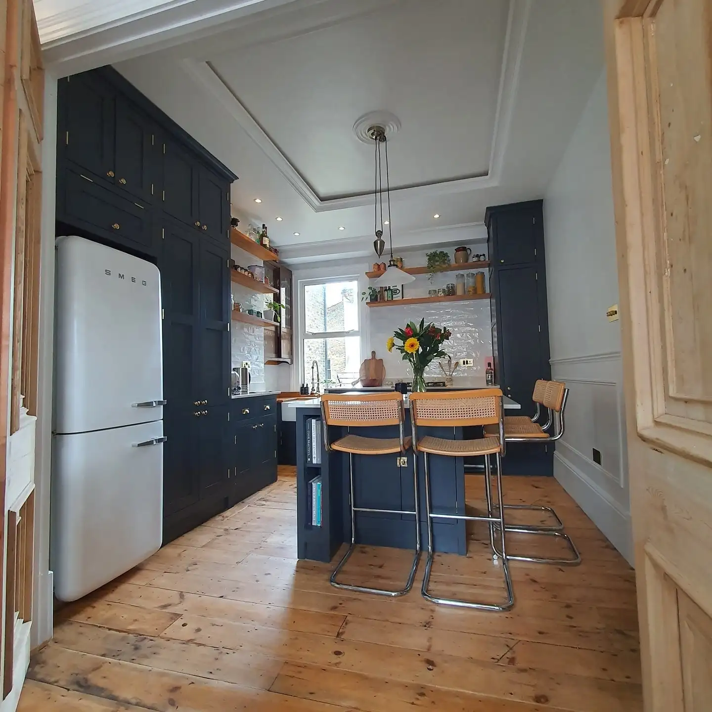 Refurbished flat: navy kitchen and restored floor