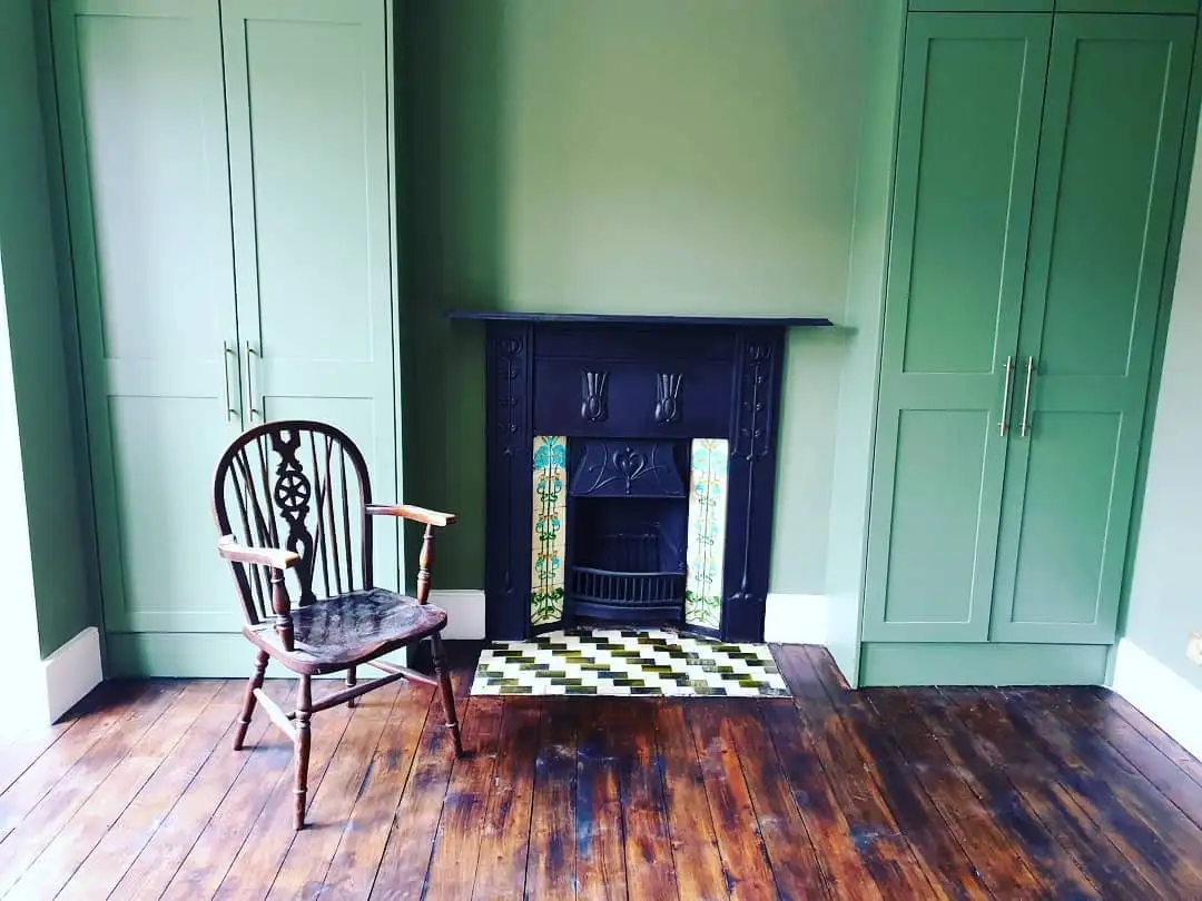 Fitted wardrobes either side of a restored fireplace