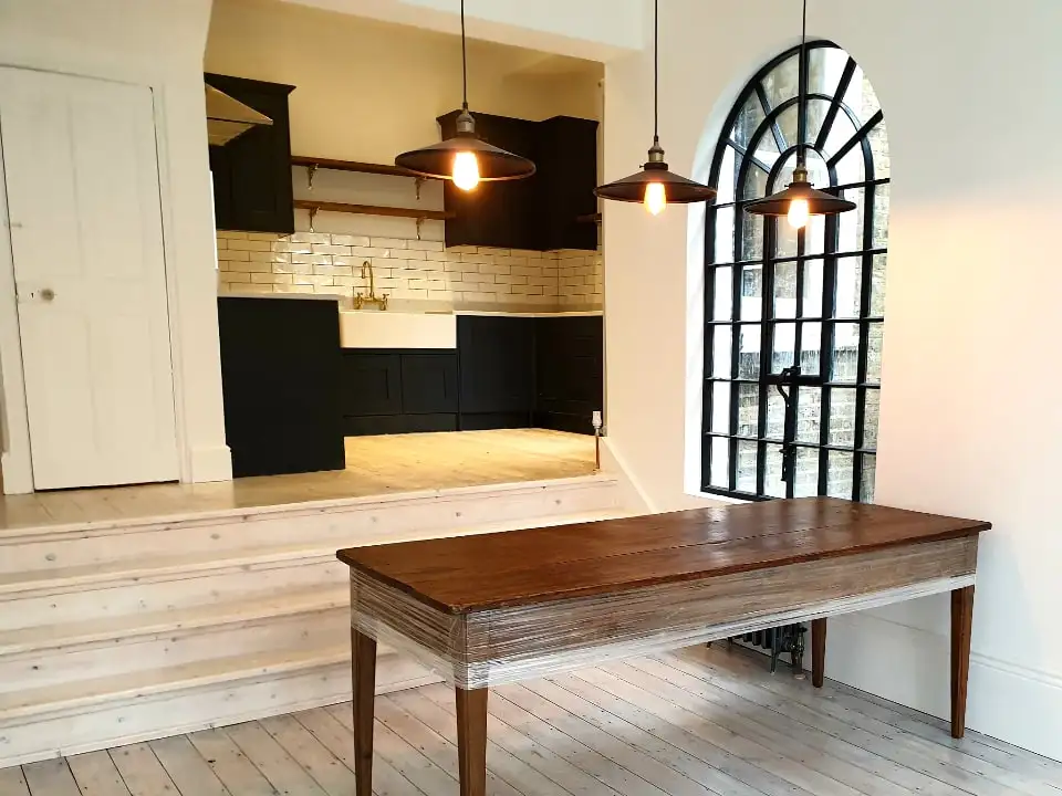 Kitchen with an arched black window and pendant lights