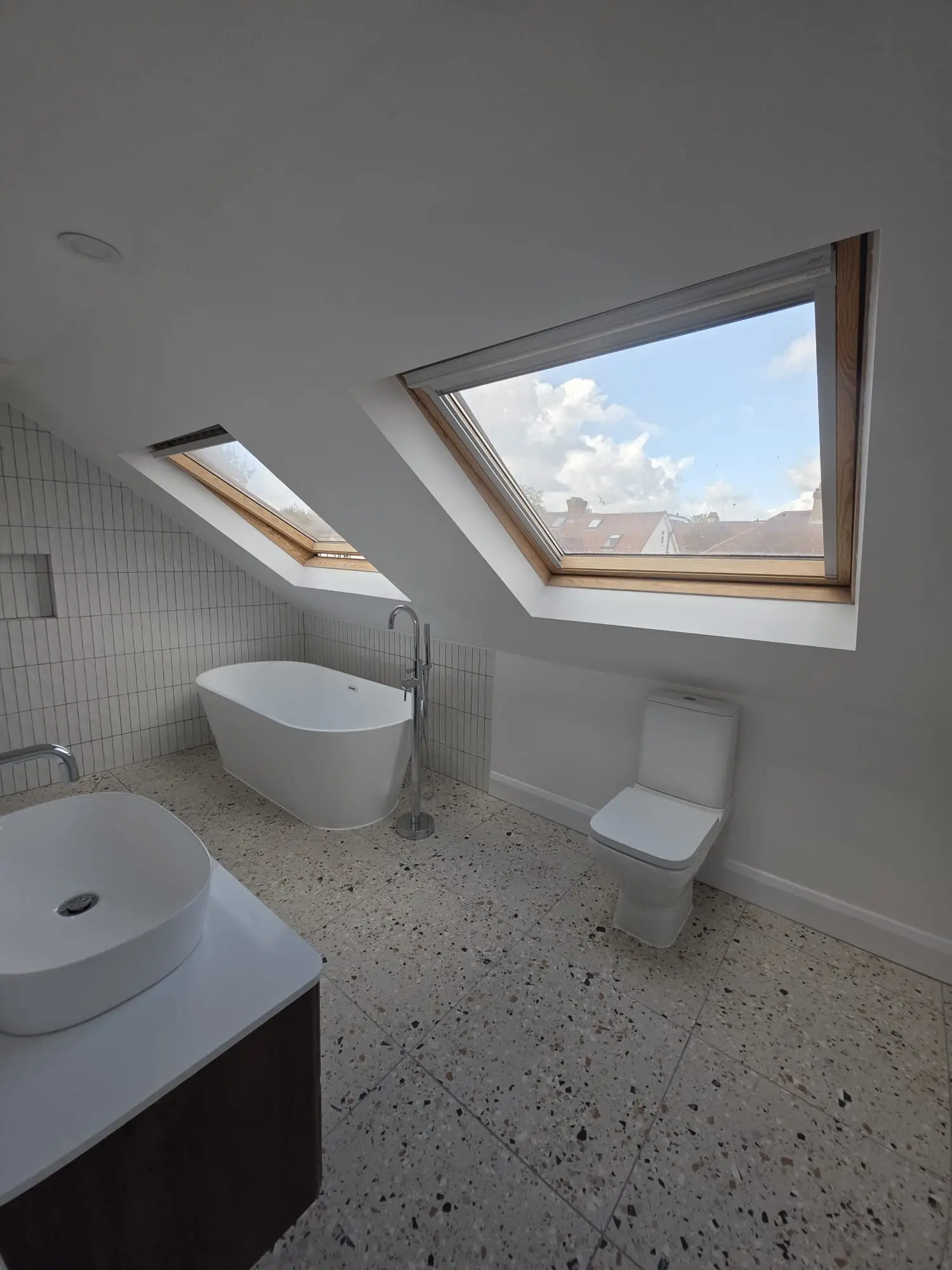 Loft bathroom with a freestanding bath under the roof windows