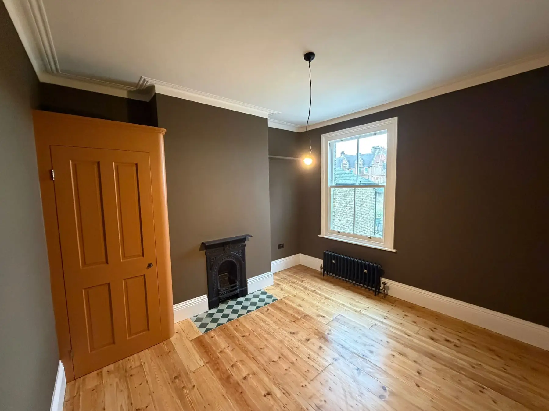 Second bedroom decorated with dark walls and white skirting