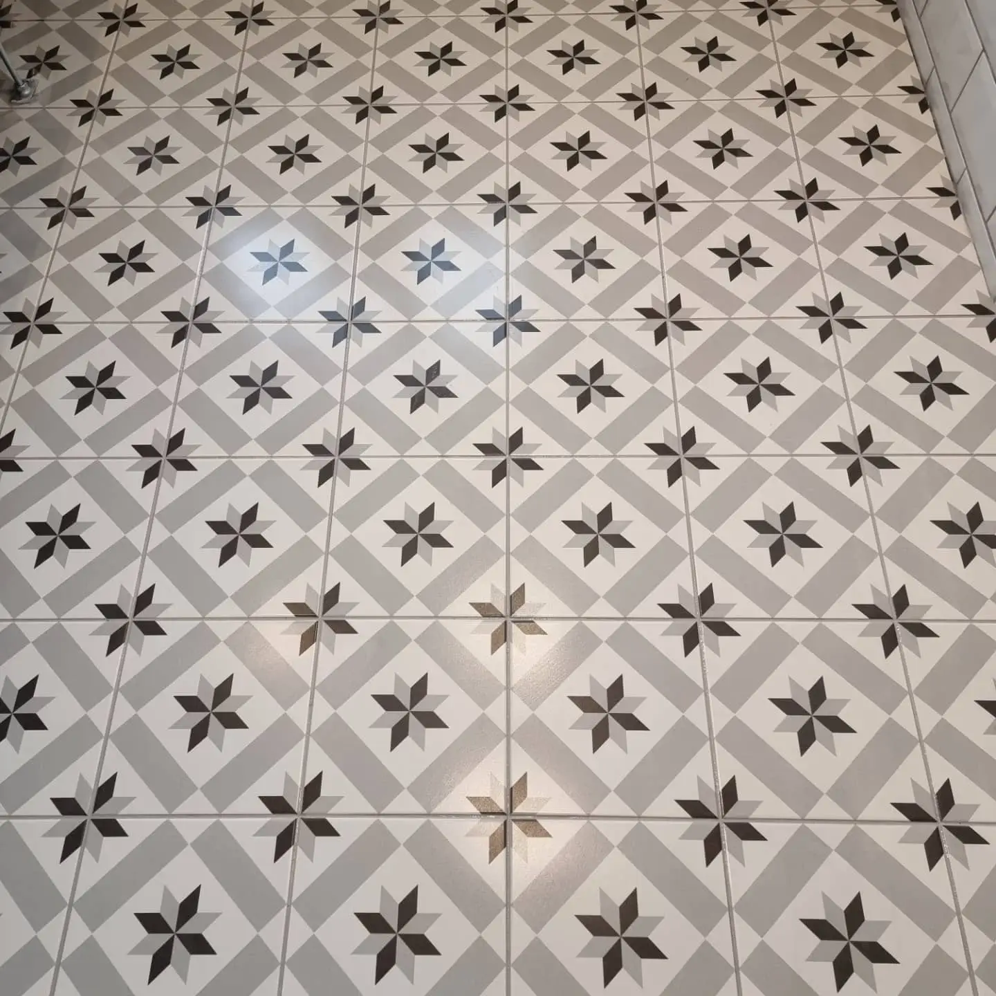 Patterned grey and white star floor tiles laid by Two Brothers Construction